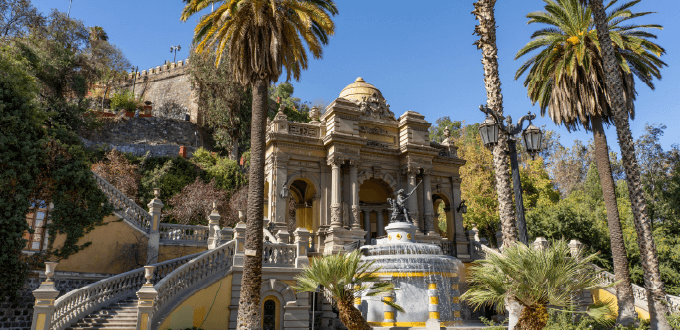 Fuente Neptuno y arquitectura histórica en el Cerro Santa Lucía, rodeado de palmeras y jardines en Santiago de Chile.