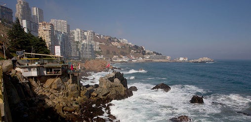 Costa rocosa del Pacífico con olas rompiendo y edificios sobre los acantilados en Viña del Mar–Concón, Región de Valparaíso, Chile.
