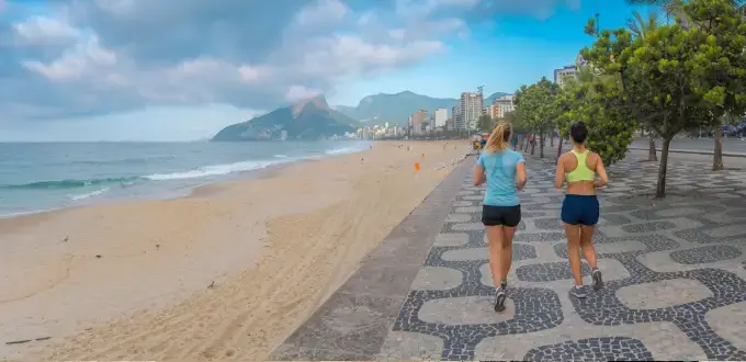 Playa de Ipanema en Río de Janeiro, Brasil, con paseo costero, mar, montaña y personas disfrutando al aire libre.