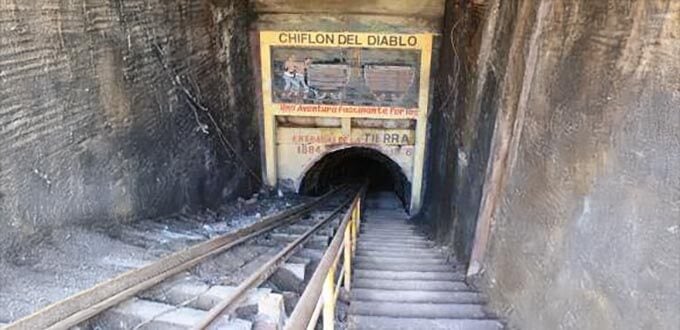 Entrada al Chiflón del Diablo con rieles mineros y escaleras hacia el túnel histórico, Lota, región del Biobío, Chile.