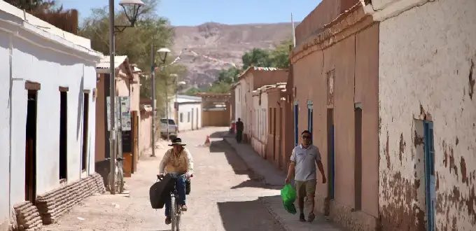 Calle de adobe con vida local en pleno desierto, arquitectura tradicional de San Pedro de Atacama, Región de Antofagasta, Chile.