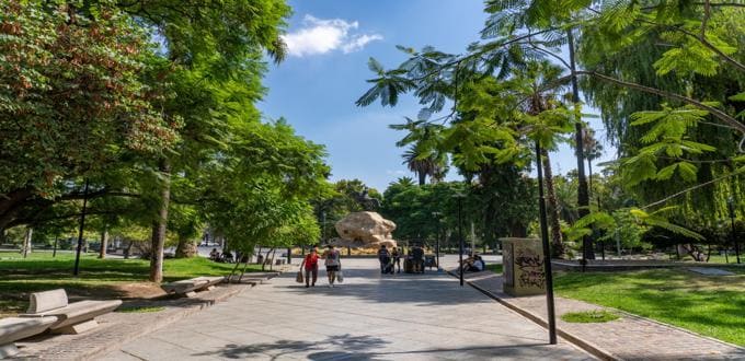 Paseo arbolado en Plaza San Martín, Mendoza (Argentina) con senderos, bancos y la escultura ecuestre central.