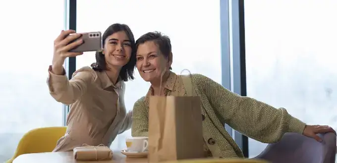 Dos mujeres se toman una selfie en una cafetería de Providencia, Santiago, durante una pausa de compras y paseo por la ciudad.