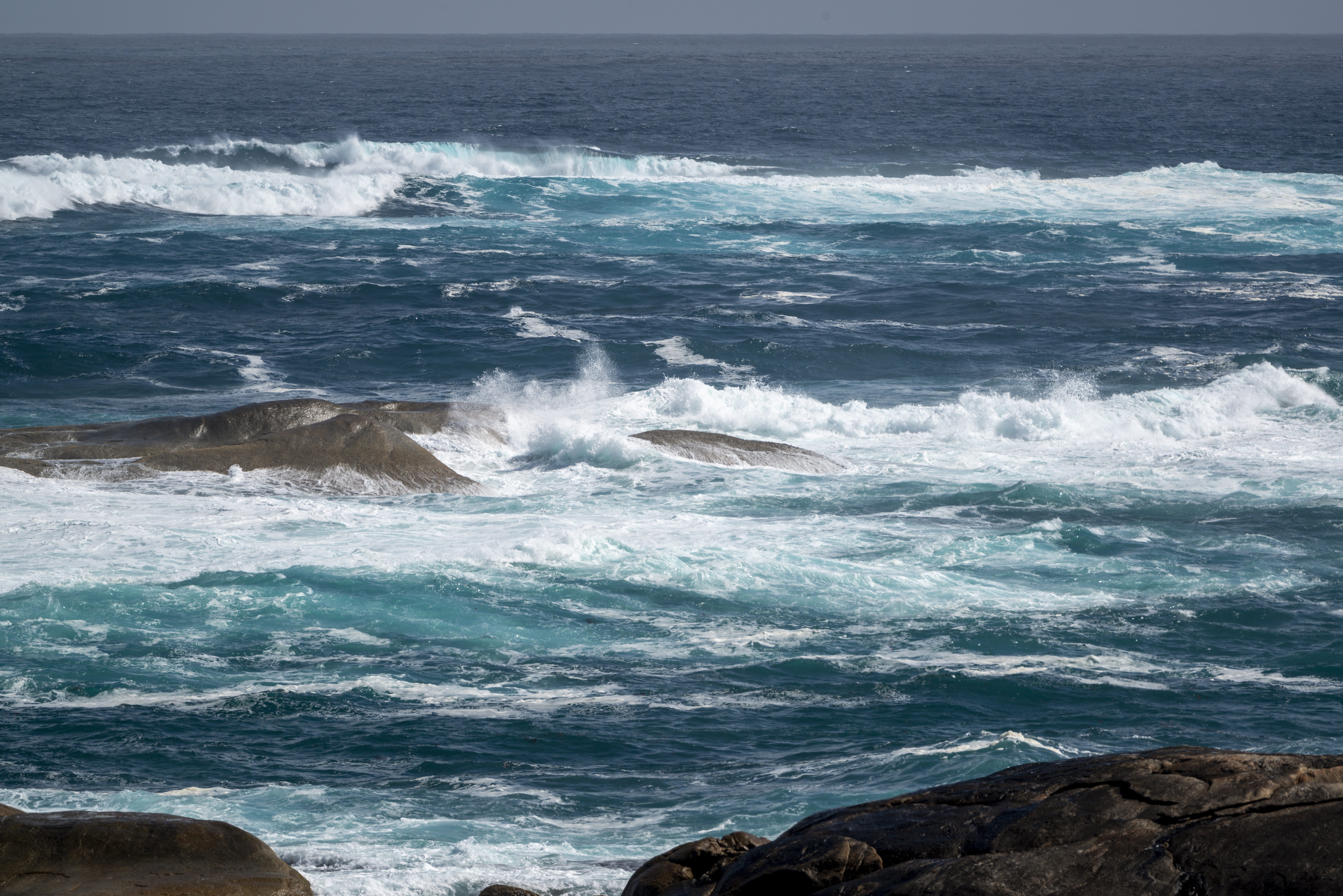 Oleaje intenso rompiendo sobre rocas en la costa del Pacífico en Isla Negra, Chile, con mar azul profundo y espuma blanca.