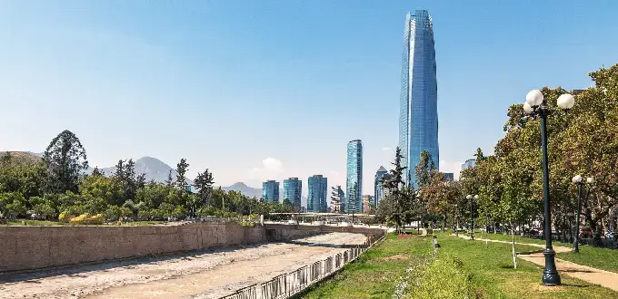 Parque a orillas del río Mapocho con la Gran Torre Santiago y rascacielos del skyline de Providencia y Costanera Center, en Santiago de Chile.