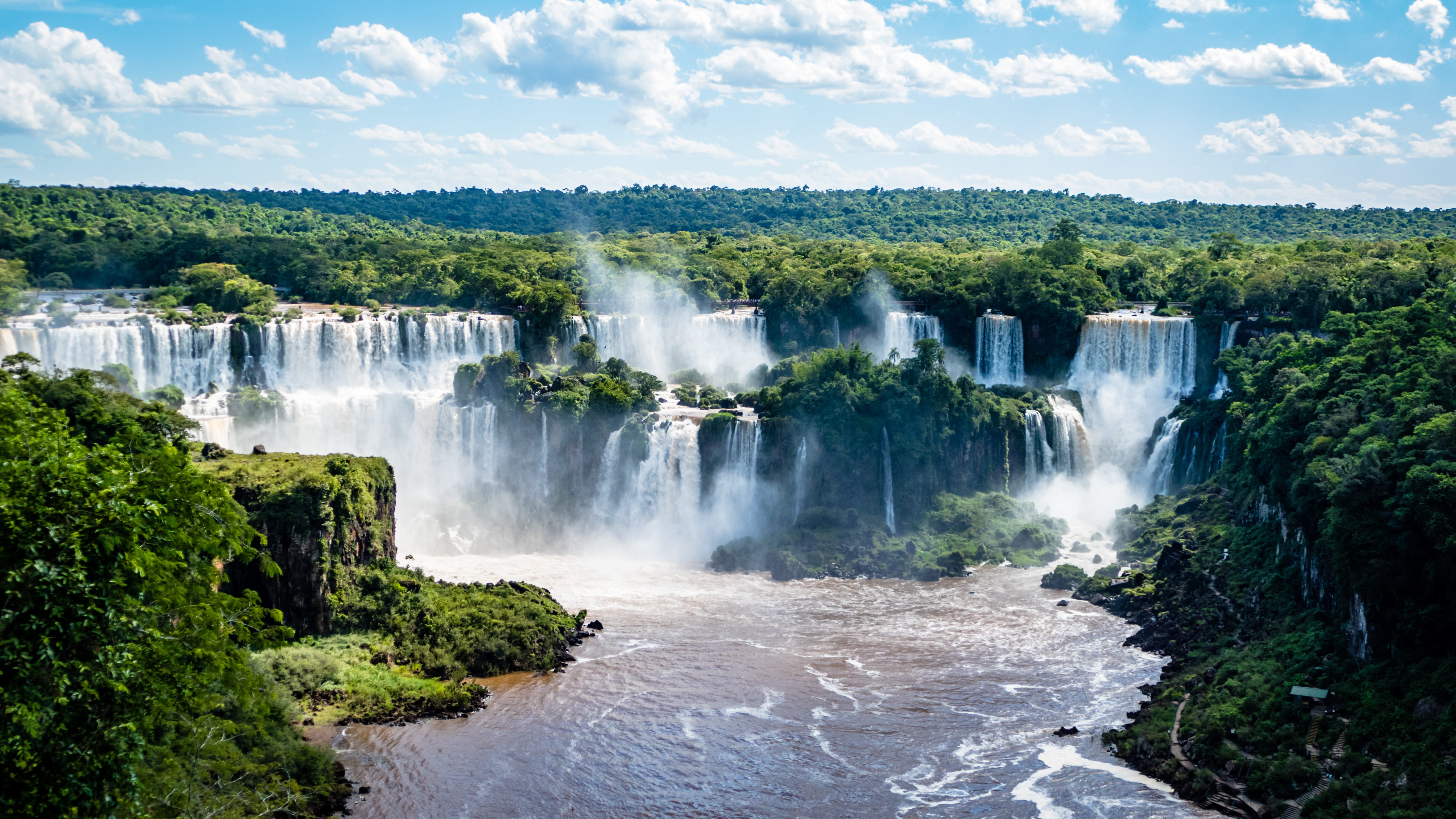 Cataratas del Iguazú en Foz de Iguazú, Brasil, rodeadas de selva tropical y cielo azul brillante