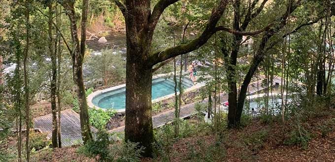 Termas naturales entre bosque nativo y río en Pucón, destino de relajación en la Región de La Araucanía, Chile.
