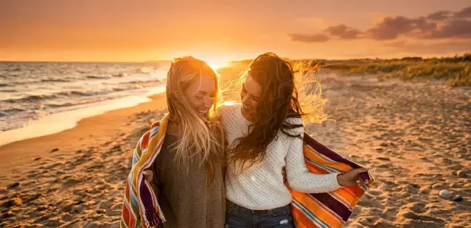 Dos mujeres disfrutan un atardecer en la playa de Mar del Plata, Argentina, junto al mar y la costa atlántica.