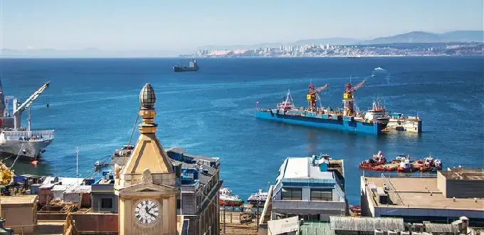 Vista del puerto de Valparaíso, Chile, con barcos, grúas y la bahía del Pacífico desde un mirador urbano.