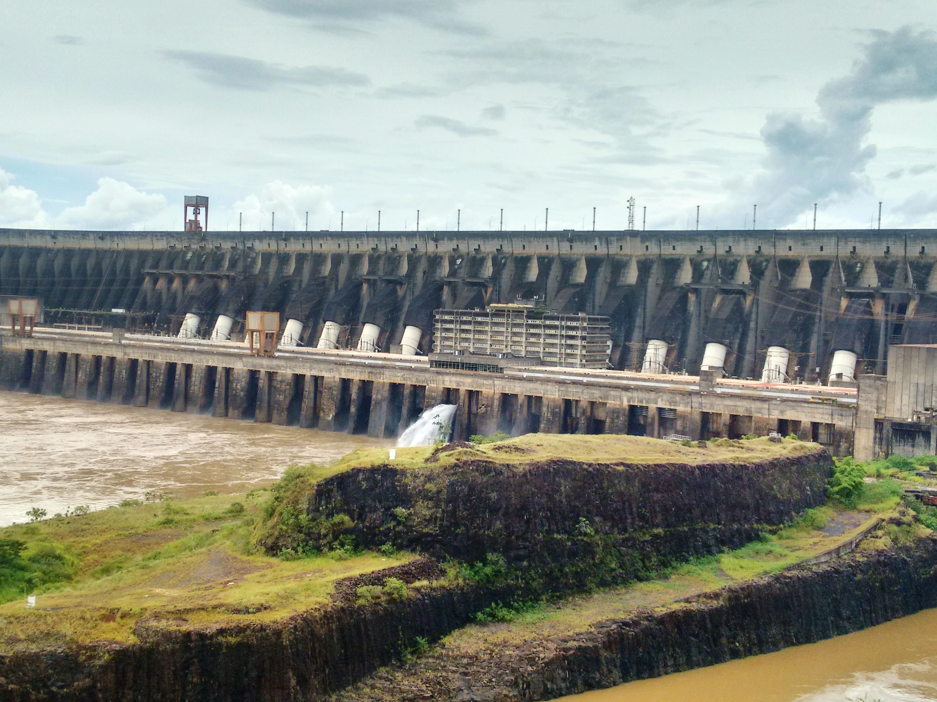 Represa de Itaipú en Foz de Iguazú, Brasil, estructura hidroeléctrica gigante junto al río Paraná y vegetación.