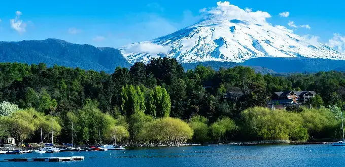 Volcán Villarrica nevado junto al lago y bosques de Pucón, Región de La Araucanía, Chile.
