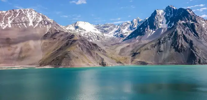 Embalse El Yeso con aguas turquesa y montañas nevadas de la cordillera de los Andes en Cajón del Maipo, cerca de Santiago de Chile.