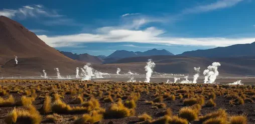 Géiseres activos entre montañas y pastizales del desierto, paisaje natural de San Pedro de Atacama, Región de Antofagasta, Chile.