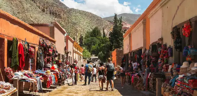 Mercado artesanal en Purmamarca, Jujuy, con textiles, artesanías y montañas de la Quebrada de Humahuaca.