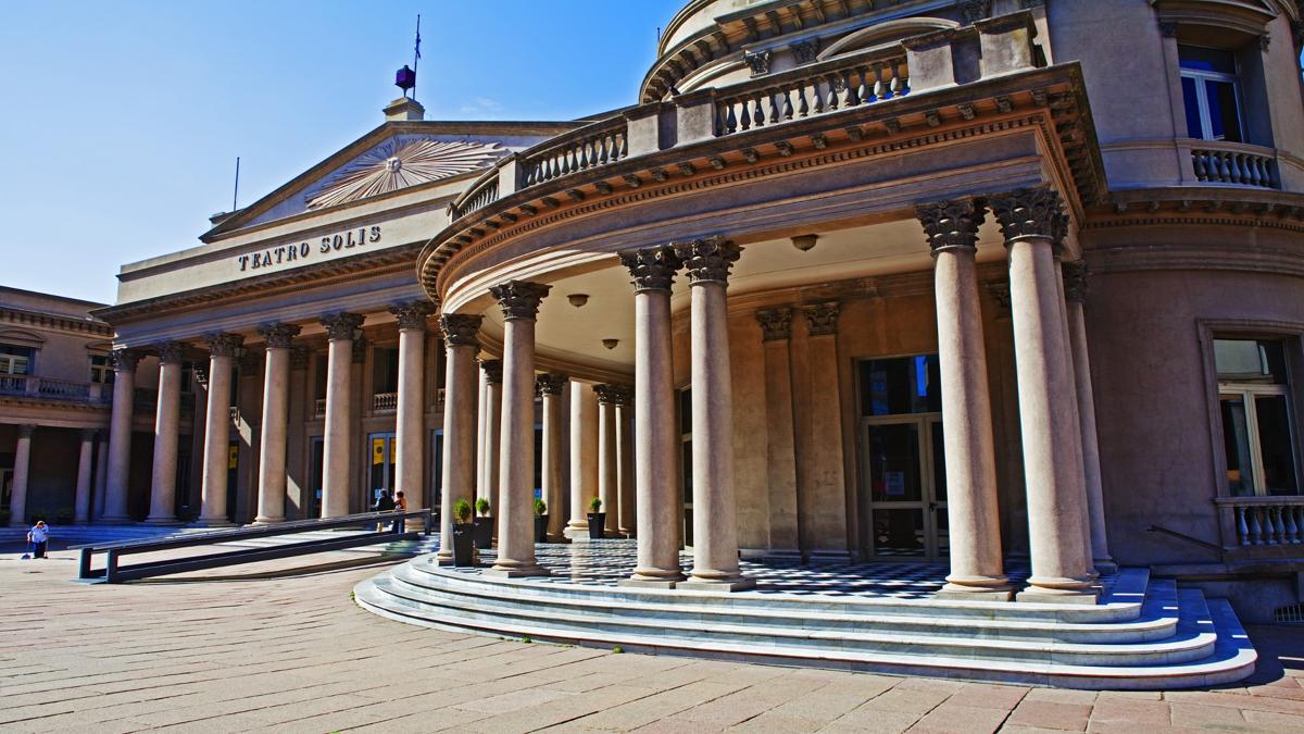 Fachada del Teatro Solís en Montevideo, con columnas clásicas y arquitectura patrimonial bajo la luz del día.