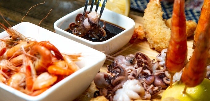 Tabla de mariscos con camarones, pulpo y frituras, acompañados de limón y salsa, típica gastronomía de La Serena, Chile.