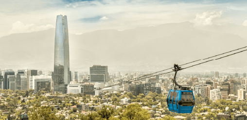 Teleférico de Santiago con vista urbana y el Costanera Center, rodeado de áreas verdes y la Cordillera de los Andes en Santiago de Chile.