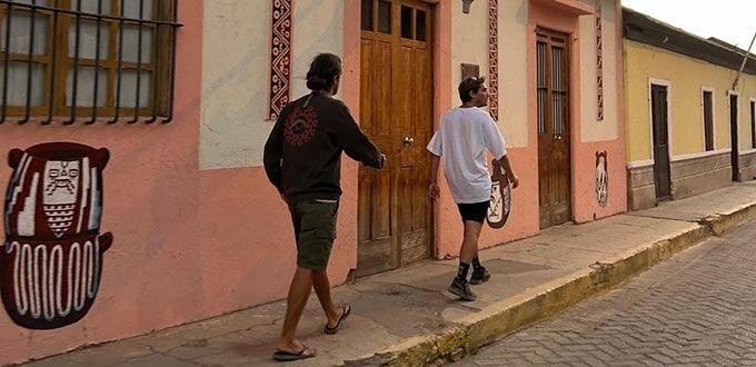 Turistas recorren calle patrimonial del Valle del Elqui, Chile, con fachadas coloridas, murales artesanales y arquitectura tradicional.