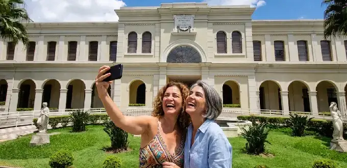 Visitantes tomándose una selfie frente al Museu da Imigração do Estado de São Paulo, Brasil.