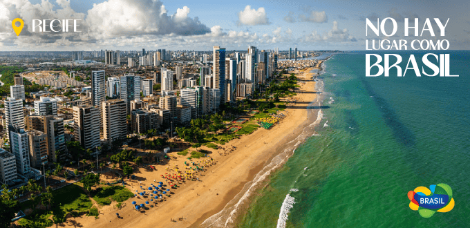 Vista aérea de la playa de Boa Viagem en Recife, Brasil, con edificios modernos y mar turquesa al fondo.