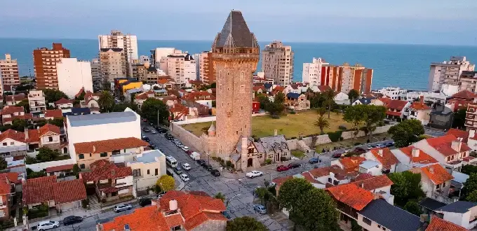 Torre Tanque de Mar del Plata, Argentina, rodeada de edificios residenciales y con el océano Atlántico al fondo.