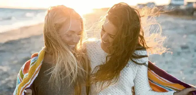 Dos mujeres disfrutan un atardecer en la playa de Mar del Plata, Argentina, junto al mar y la costa atlántica.