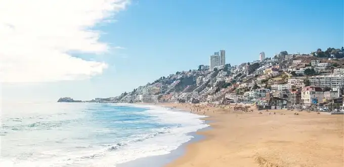 Playa de Reñaca en Viña del Mar con edificios en los cerros, arena amplia y olas del Pacífico en la costa central de Chile.