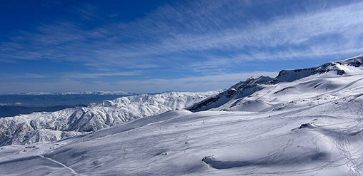 Panorámica de montañas cubiertas de nieve y pistas invernales, paisaje de alta cordillera en Farellones, Región Metropolitana, Chile.