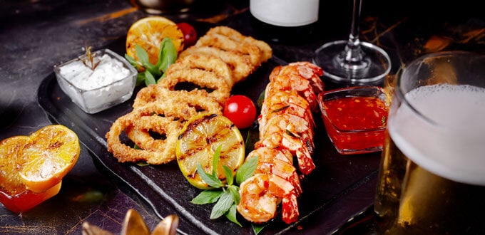 Tabla gastronómica con mariscos y frituras, camarones y calamares, cerveza y vino, cocina costera en Concón, Región de Valparaíso, Chile.