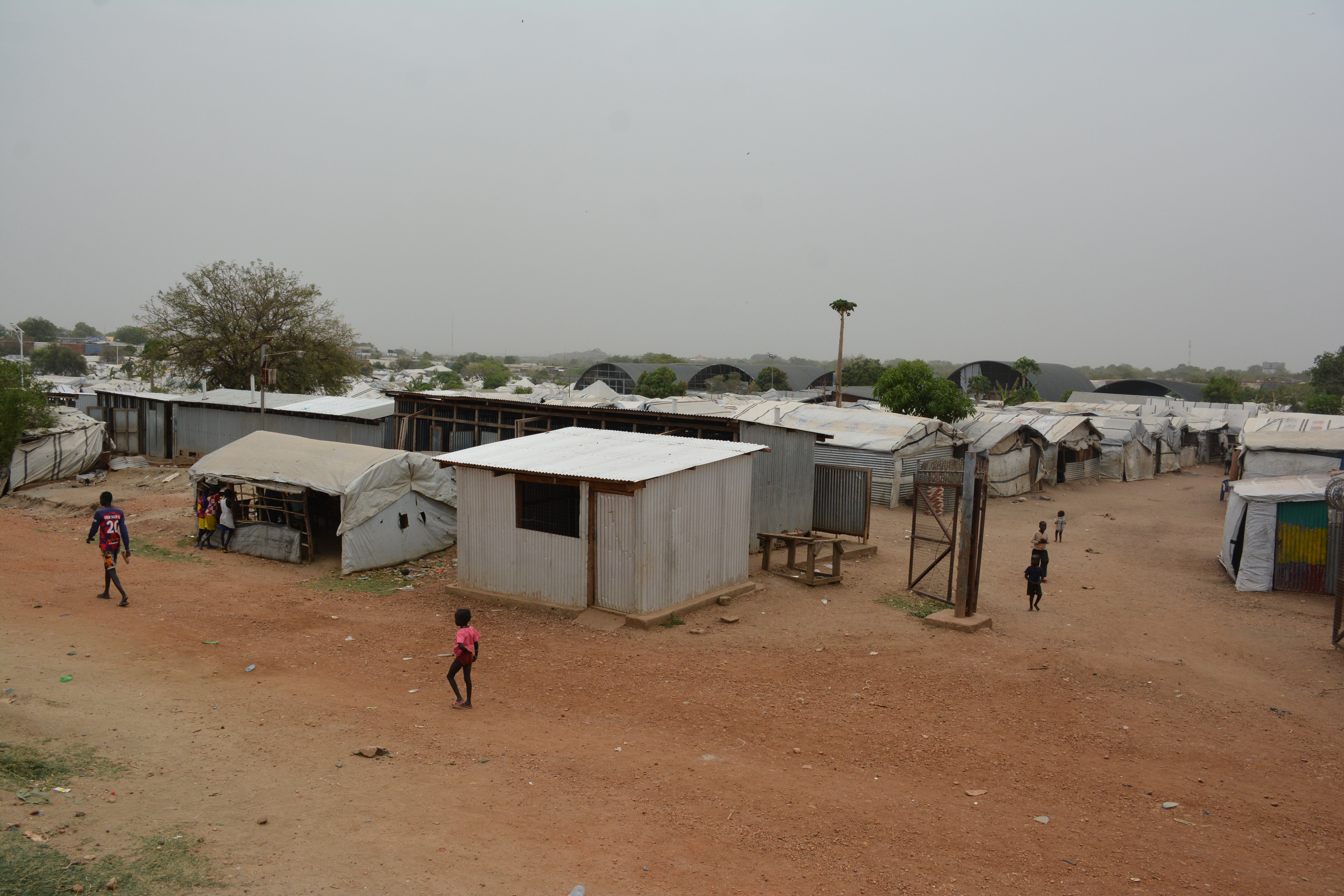 Wide shot image of an outdoor area with shed-structured buildings.  