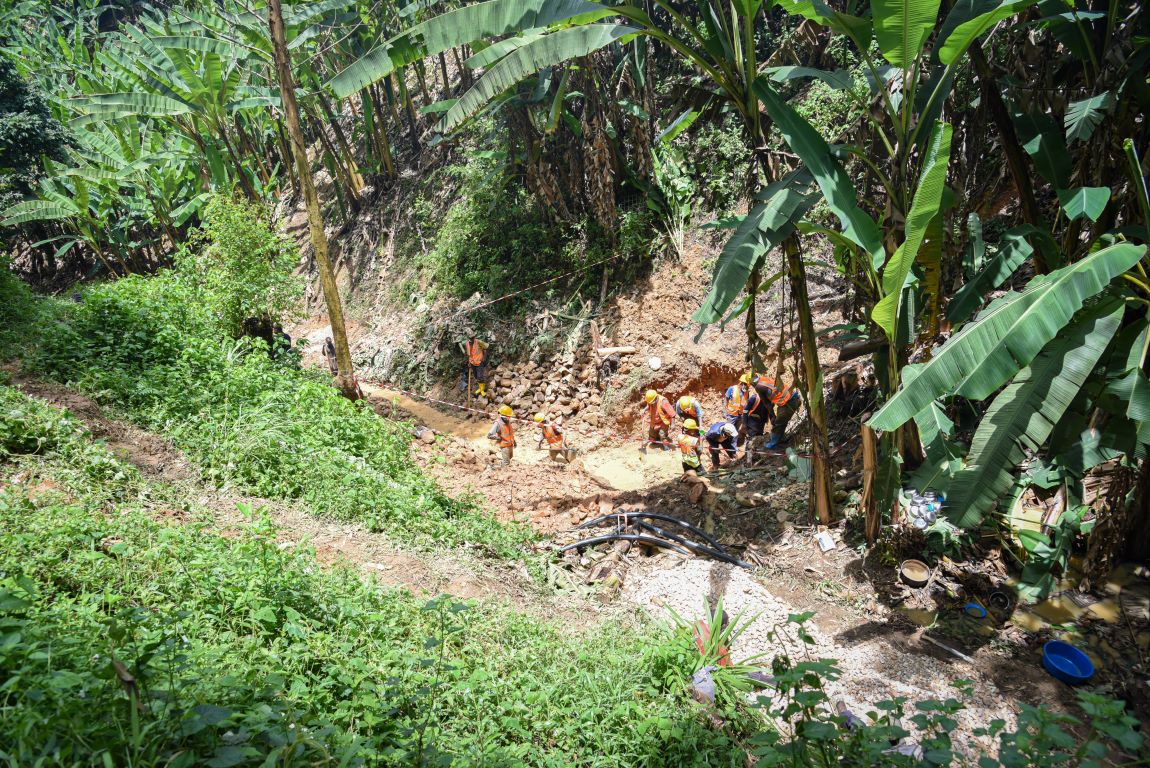 In the Democratic Republic of the Congo, construction workers are seen working at the center of a lush jungle. 