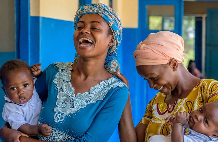 Two women wearing traditional clothing, laughing together.