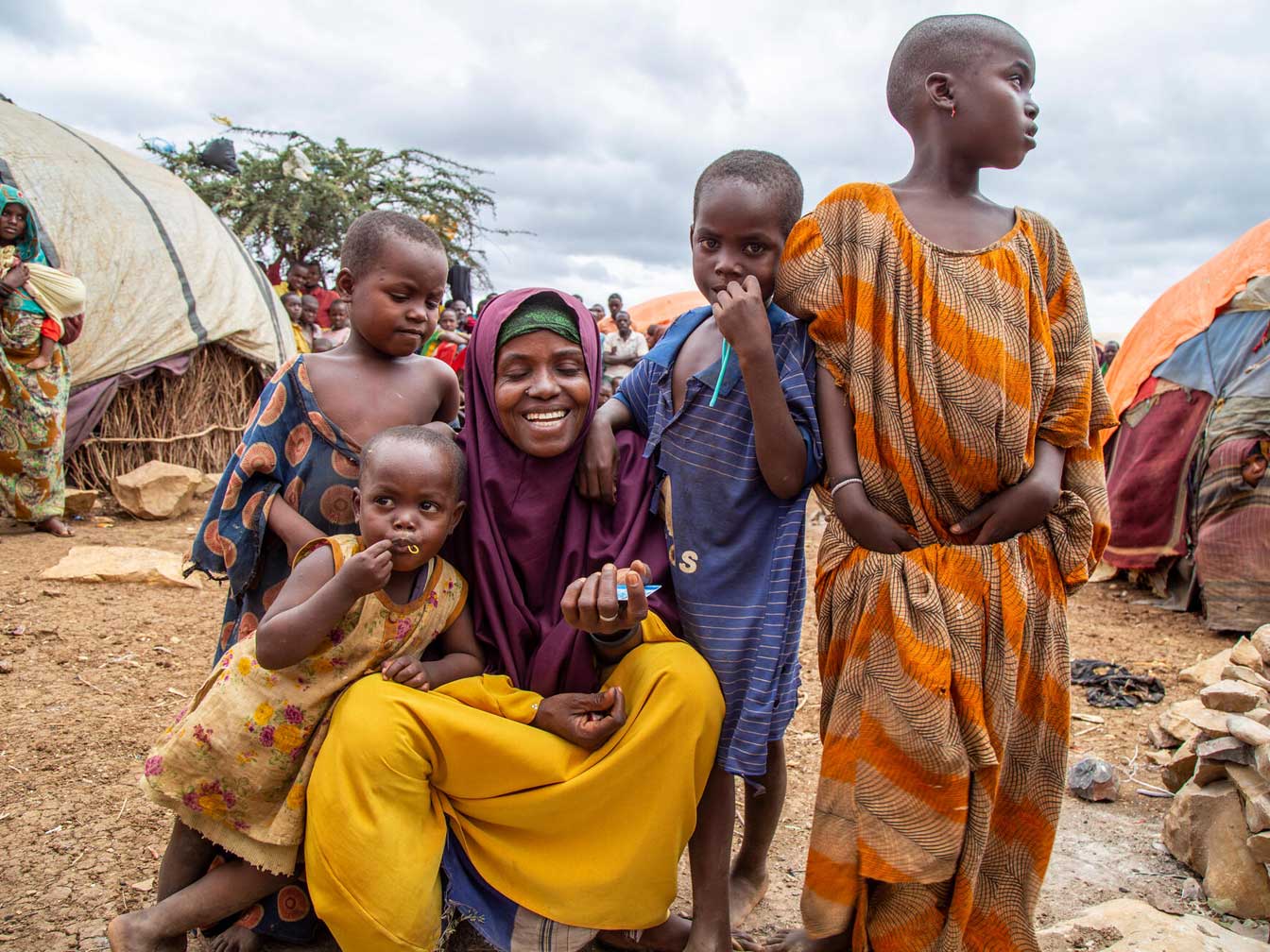 A mother and her four children, posing for a photo dressed in colourful garments.
