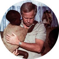 A man carrying a severely malnourished child.