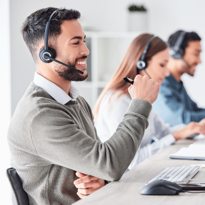Three people working at desks with headsets on