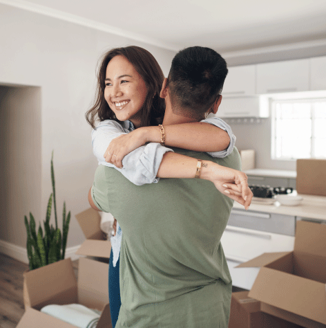 Young couple hugging near moving boxes