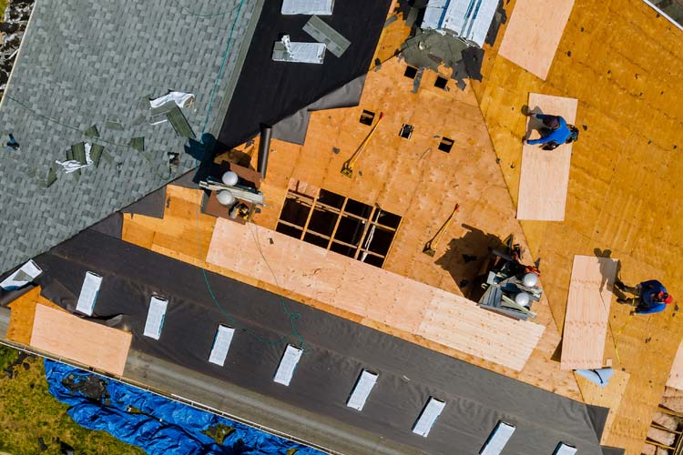 Roofer nailing shingles with air gun and replacing roof cover protection. How to Protect Yourself from Shady Roofing Insurance Scams in Illinois