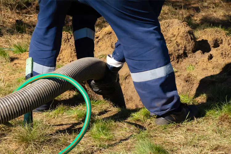 Worker holding pipe, fixing sewage line. Who's responsible when sewage lines bust in Mississippi? 