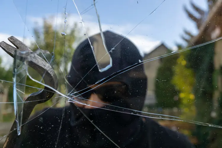 Burglar with obscured face trying to break window of house. If a Home Is Broken Into but Nothing is Stolen, What Coverage Do I Need?
