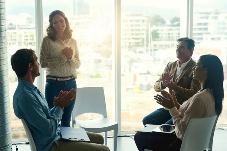Group of businesspeople applauding their colleague during a meeting in the office. Steps to Effective Reputational Risk Management. 