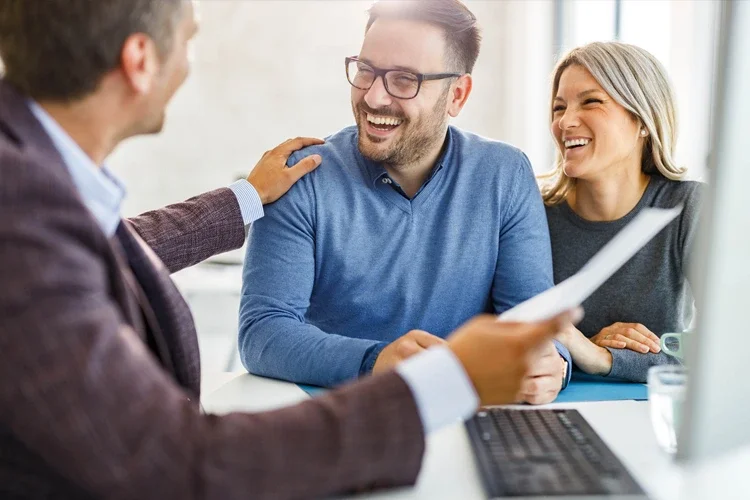 Couple talking to their insurance agent about paperwork in the office. Is Insurance Recession-proof?