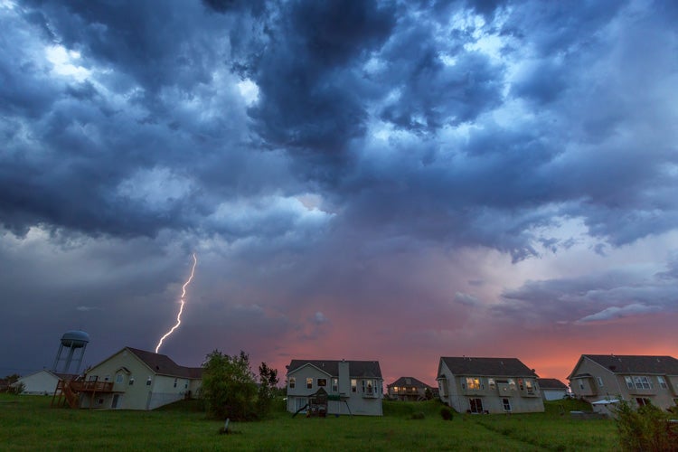 A supercell storm creates lightening over a residential neighborhood. Do Mississippi homes in heavy tornado areas cost more to insure?