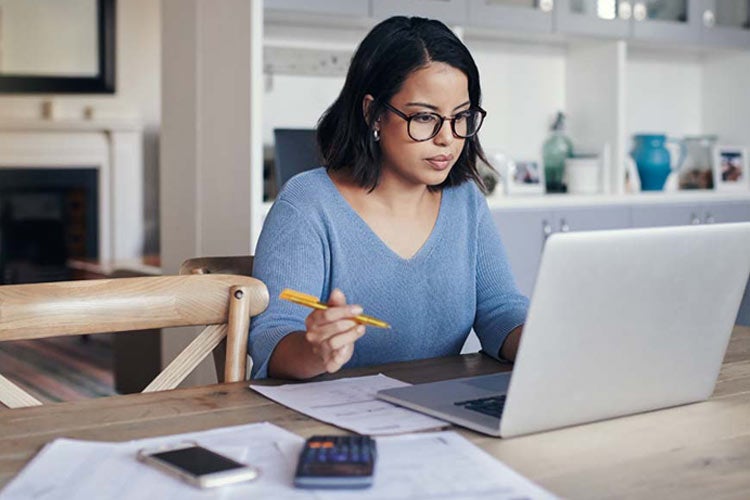 Young woman using a laptop to compare car insurance rates