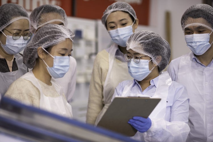 Workers masked and dressed in PPE