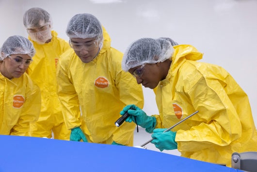Group of participants in yellow PPE learning from Trainer in wet breakout