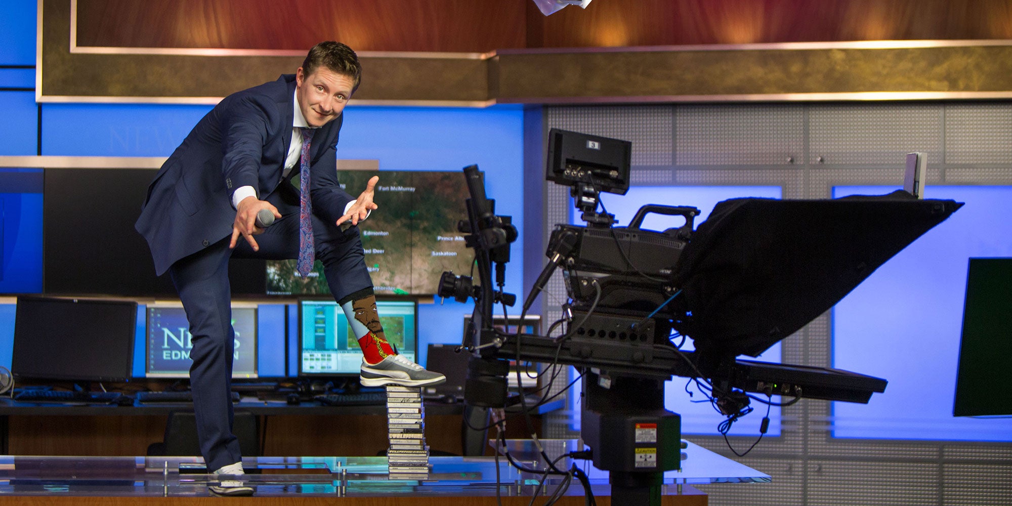 A man in a suit jumping on a stack of books