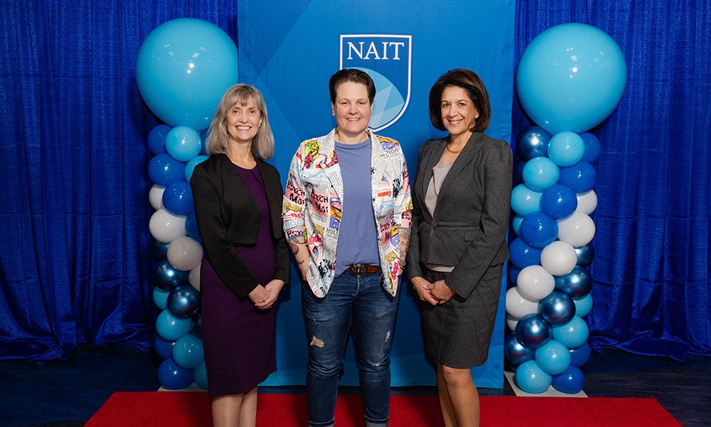 A group of women standing in front of a blue and white backdrop