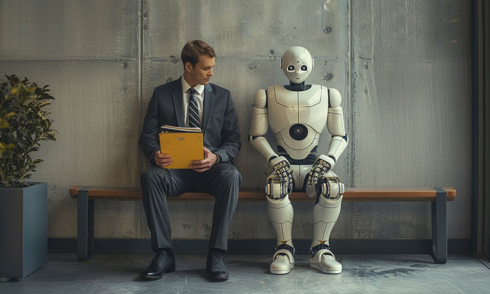 A man sitting on a bench next to a robot