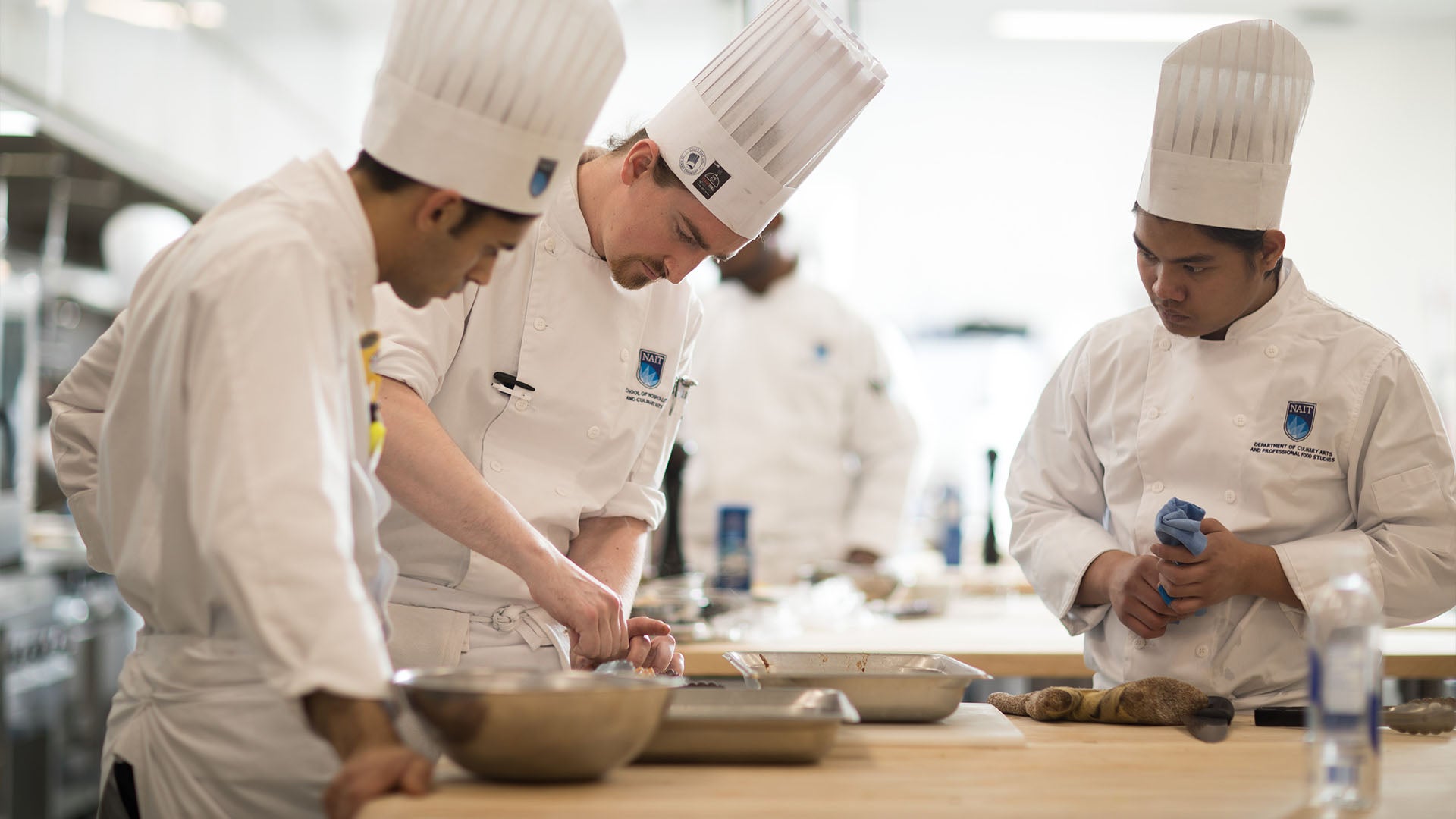 Three cooks working at a station.
