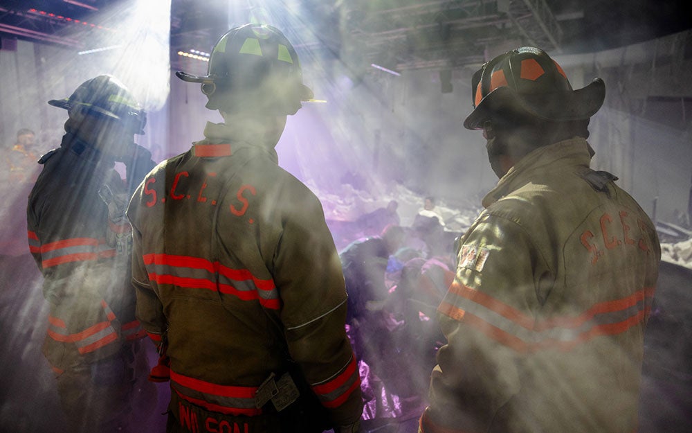 A group of firefighters in a room with smoke